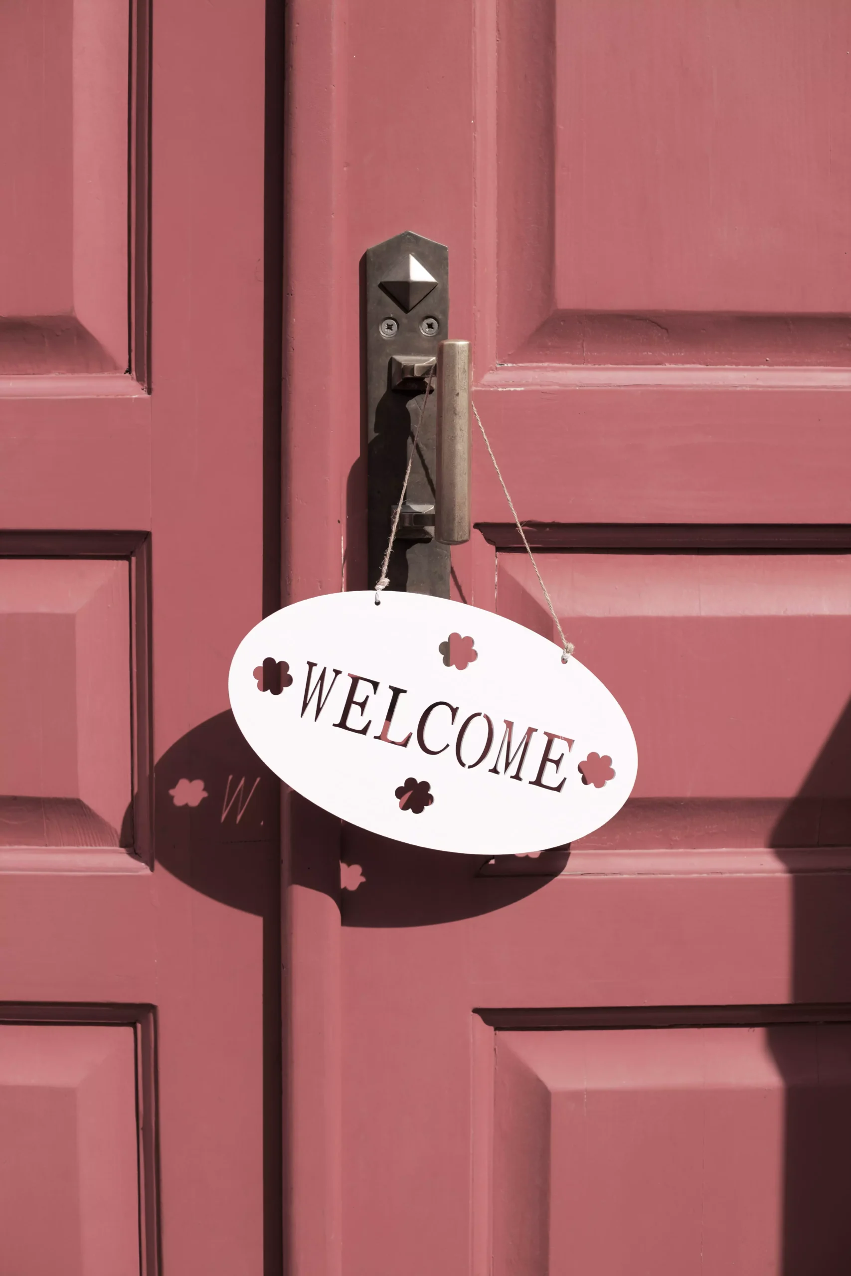 porte d'entrée rouge avec un panneau welcome